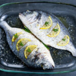 Fresh Raw Sea Bream Fish with herbs. ready to cook in oven. background